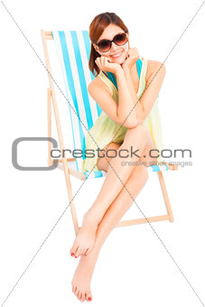 pretty sunshine girl smiling and sitting on a beach chair