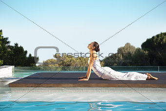 Peaceful brunette in cobra pose poolside