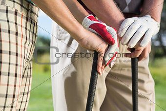 Golfing couple standing holding their clubs