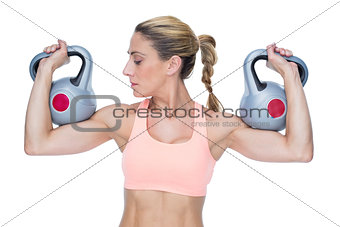 Strong female crossfitter lifting kettlebells