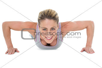 Strong woman doing press ups smiling at camera