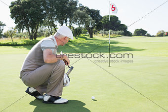 Golfer on the putting green at the eighteenth hole