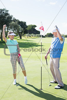 Cheering golfing couple on the eighteenth hole