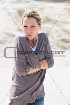 Shivering blonde woman standing on the beach
