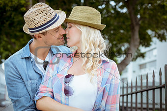 Hip young couple kissing by railings