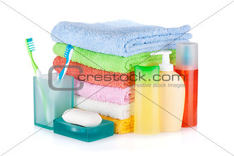 Two colorful toothbrushes, cosmetics bottles, soap and towels