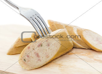 Sausage on a fork and cutting board