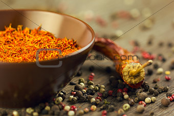 Saffron in brown bowl with chili and pepper