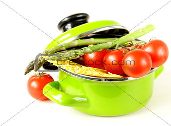 green pot full of vegetables (tomatoes, asparagus, mushrooms, broccoli) and pasta