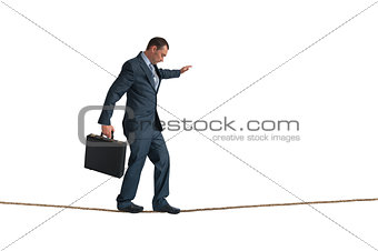 isolated businessman balancing tightrope