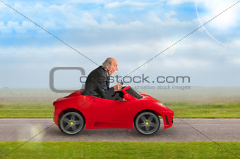 senior man driving a toy racing car