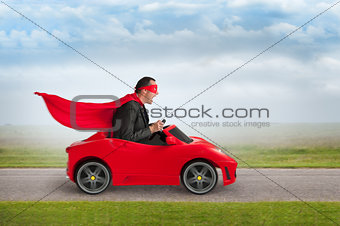 superhero man driving a toy racing car