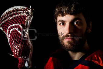 Lacrosse player holding stick with ball.