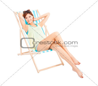 beauty sunshine girl smiling and lying on a beach chair