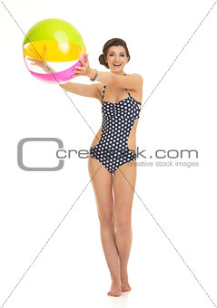 Full length portrait of happy young woman in swimsuit with beach