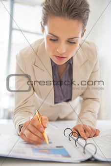Business woman writing in document