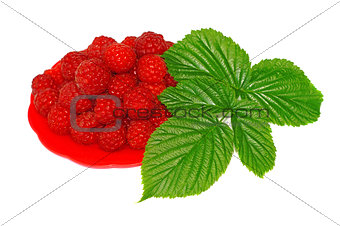 Ripe raspberries decorated with green leaf in a small platter   