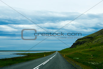 Road against mountain background, Iceland, cloudy summer weather