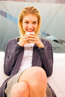Smiling young woman holding cup