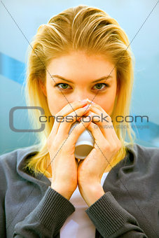 Close-up of blonde young woman drinking tea