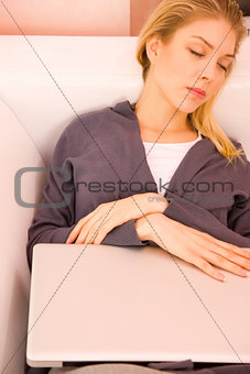 Young woman resting sofa while using laptop