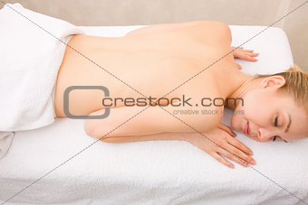 Topless young woman lying massage table