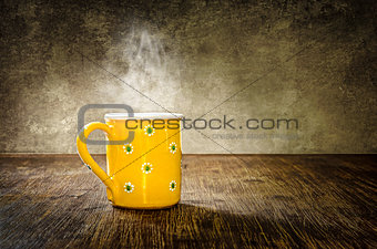 Colorful steaming coffee mug on the table