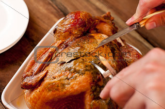 Man carving a delicious brown roast chicken