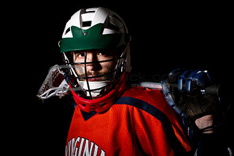 Lacrosse player wearing helmet and holding stick.