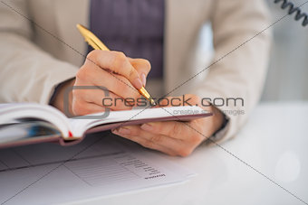Closeup on business woman writing in diary