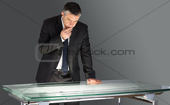 Concentrating businessman leaning on desk
