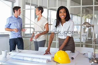 Workers loooking over plans and smiling at camera