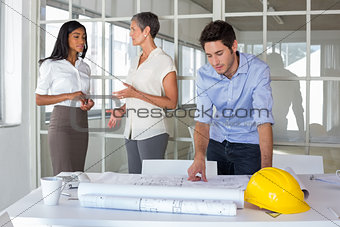 Workers talking and looking over plans