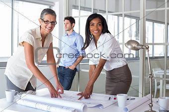 Smiling architects analyzing plans together