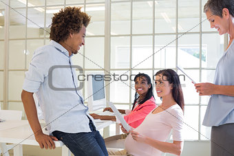 Pregnant casual businesswoman talking with colleagues