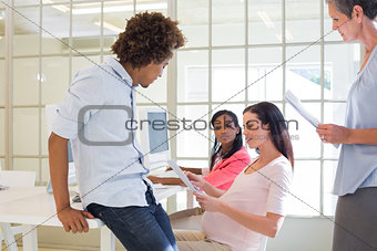 Pregnant casual businesswoman talking with colleagues