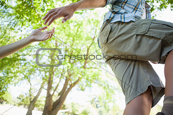 Man giving helping hand to girlfriend on hike