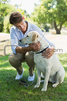 Handsome smiling man with his labrador in the park