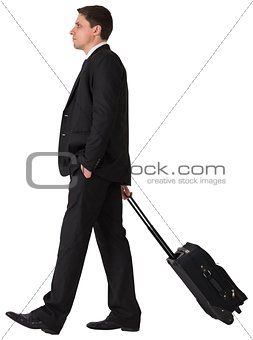 Handsome businessman pulling his suitcase