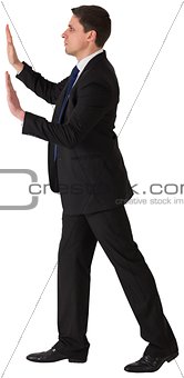 Businessman in suit pushing with hands