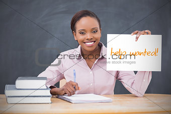 Happy teacher holding page showing help wanted