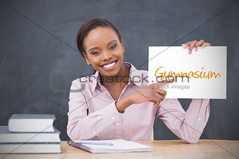Happy teacher holding page showing gymnasium