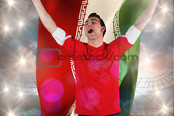 Composite image of excited football fan cheering holding iran flag