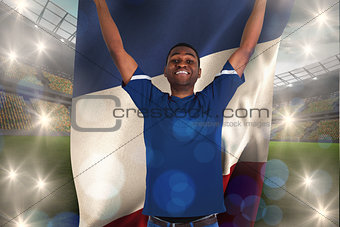 Composite image of cheering football fan in blue jersey holding france flag