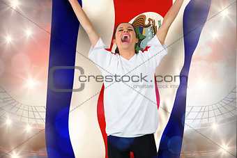 Composite image of football fan in white cheering holding costa rica flag