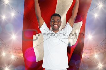 Composite image of excited handsome football fan cheering holding swiss flag