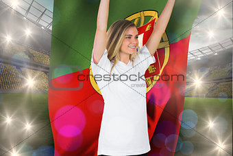 Composite image of pretty football fan in white cheering holding portugal flag