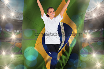 Composite image of excited football fan in white cheering holding brazil flag