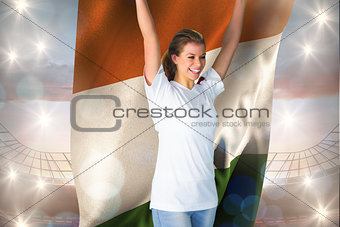 Composite image of pretty football fan in white cheering holding ivory coast flag