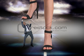 Composite image of female feet in black sandals stepping on businessman